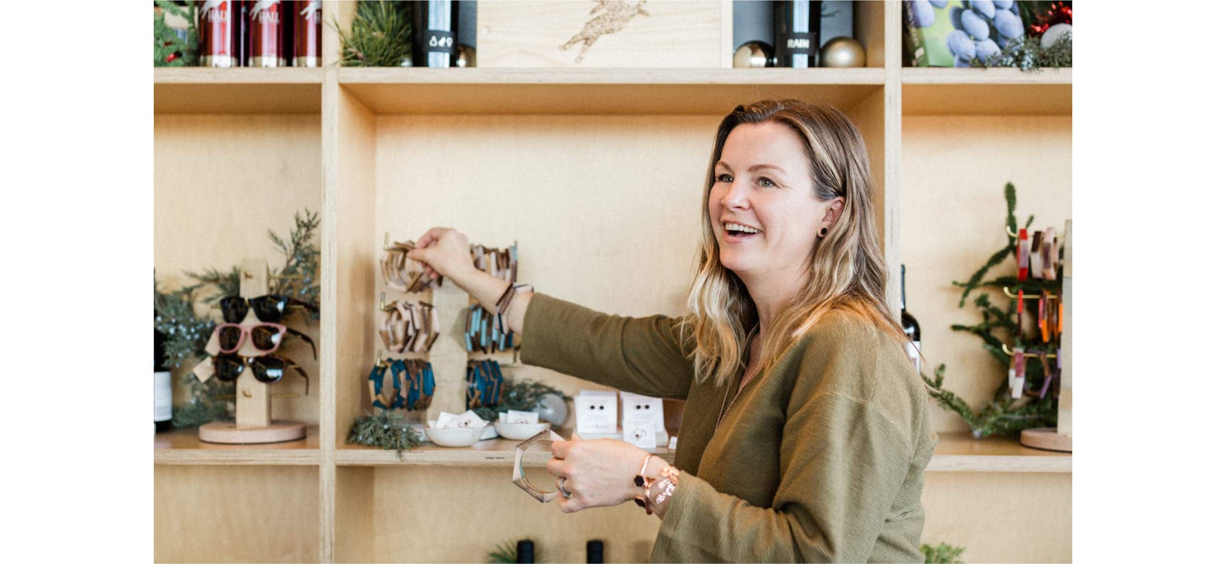 Nicole Hughes arranging bracelets on a stand in her store, Olive and Poppy.